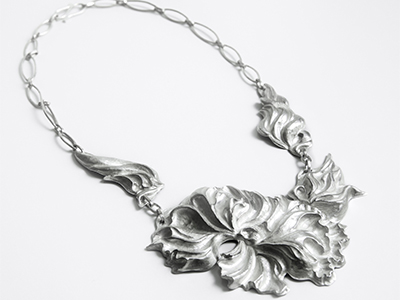 large statement silver necklace with swirling flower 