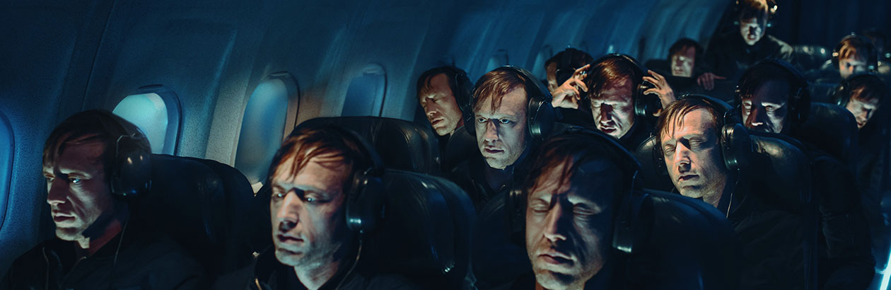 People on a plane in the dark wearing headphones