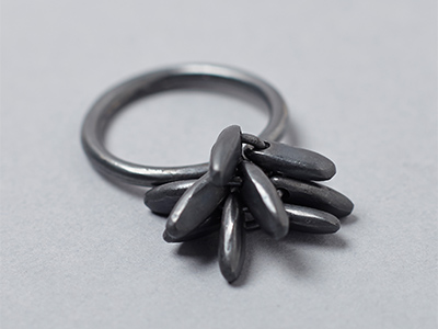 Jo Lavelle ring with dark grey seed like structure on top