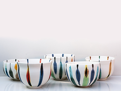 Five white, blue, green, and orange hand thrown porcelain bowls