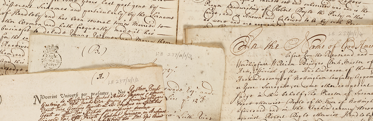 Photograph of paper manuscripts with writing scattered on a table in a pile
