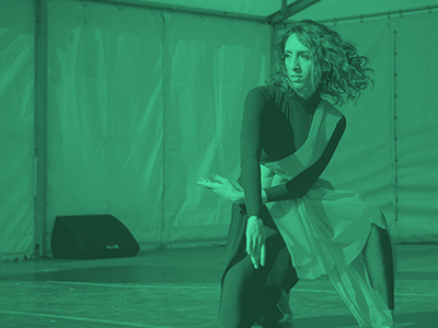 Photograph of woman dancing on stage with green colour opaque overlay