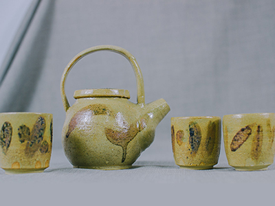 A ceramic tea set of yellow with abstract pattern