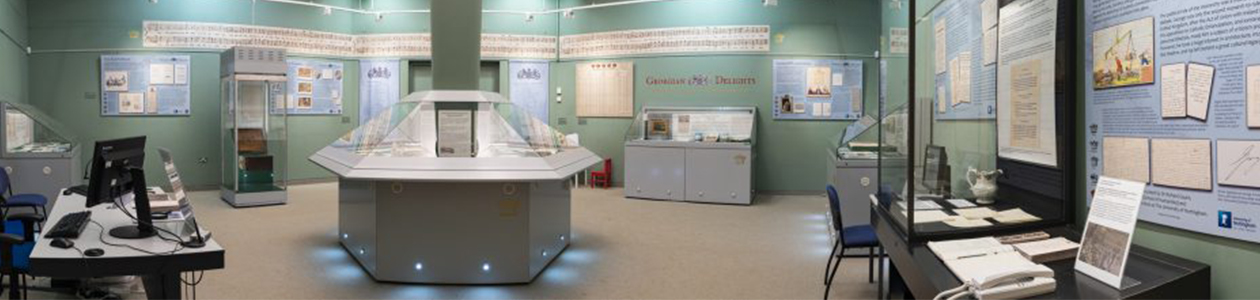 Panorama image of inside Lakeside's Weston Gallery. Image, cabinets and posters on surrounding walls with central exhibition stand.